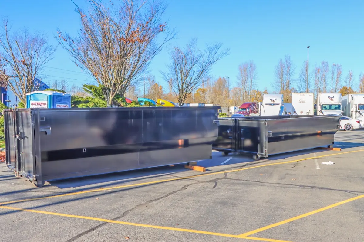 Professional dumpster rental service with roll-off container on residential driveway in Gray